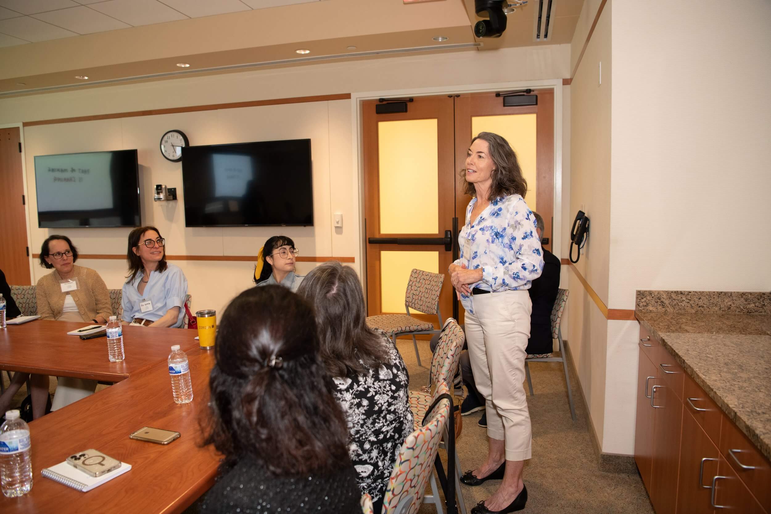 woman standing and speaking at table conversation