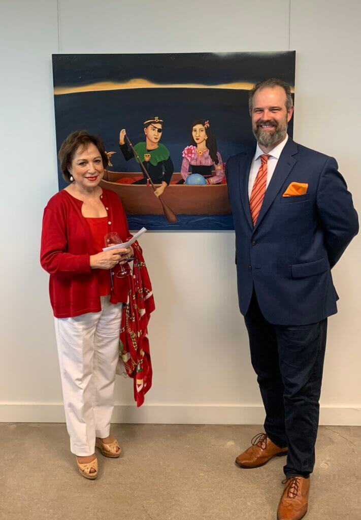 woman and man posing in front of painting