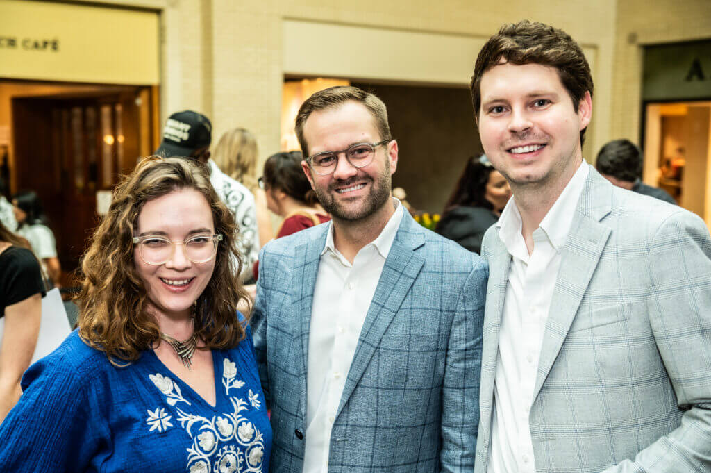 two men and a woman smiling