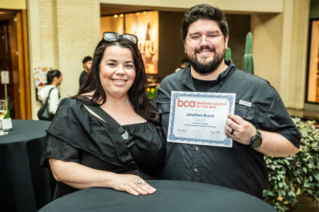 woman and man smiling holding award