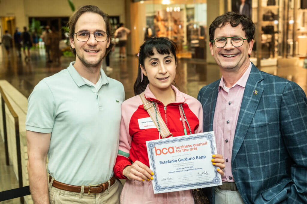 two men and a woman holding an award