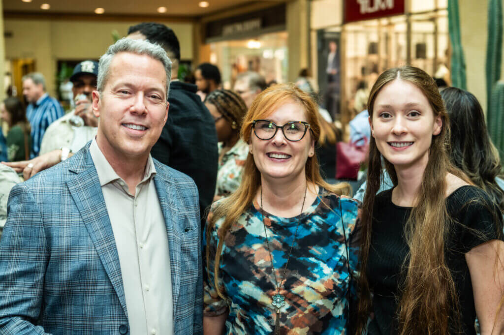 man posing with two women