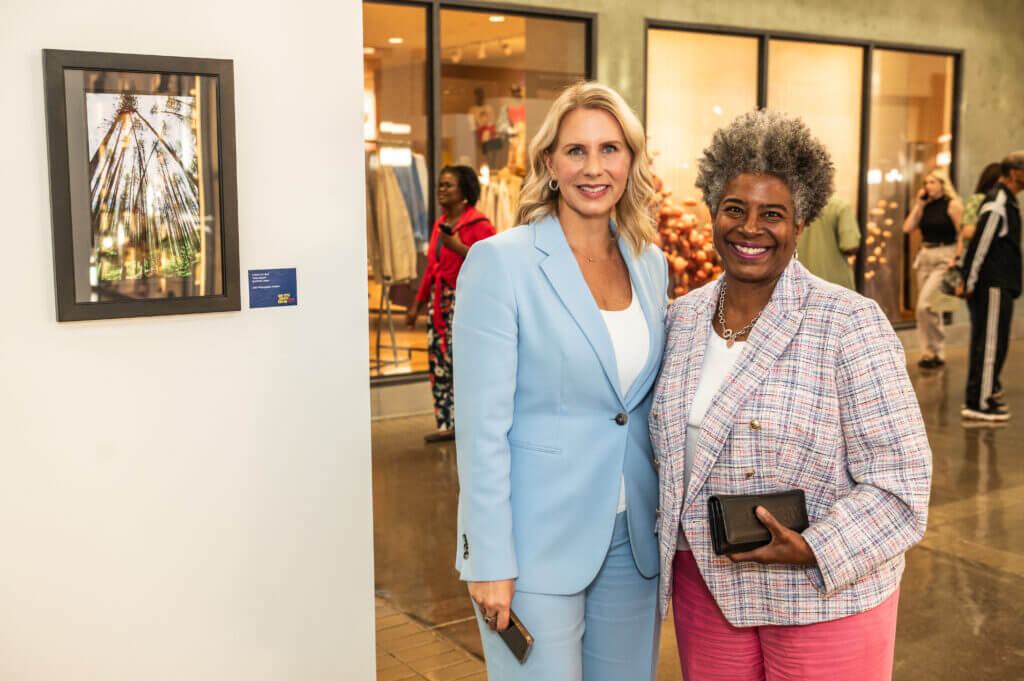 two women posing by art