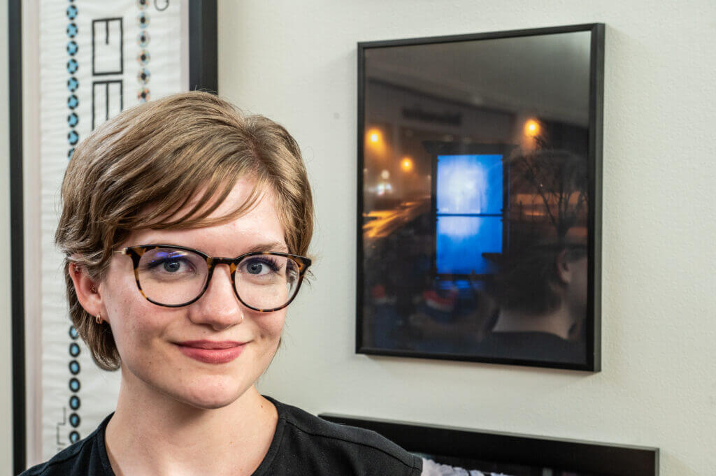 woman posing by art of window