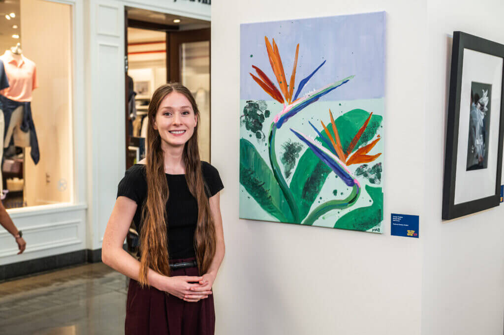 woman posing by art of flowers