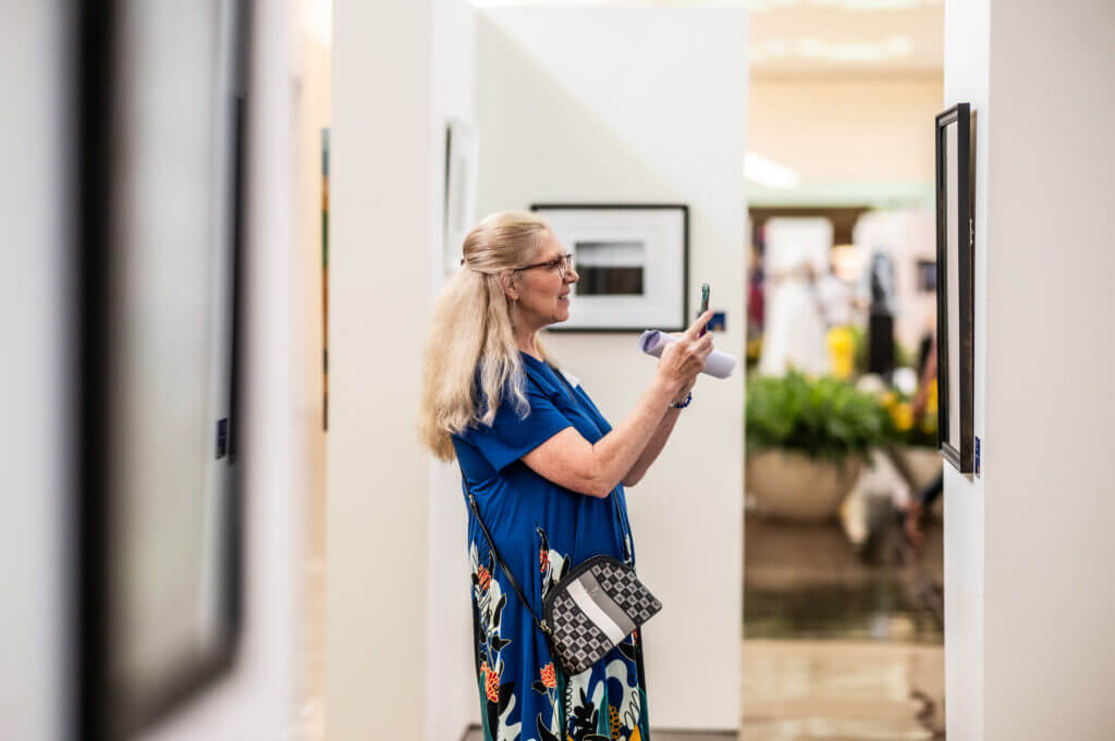 woman taking picture of art