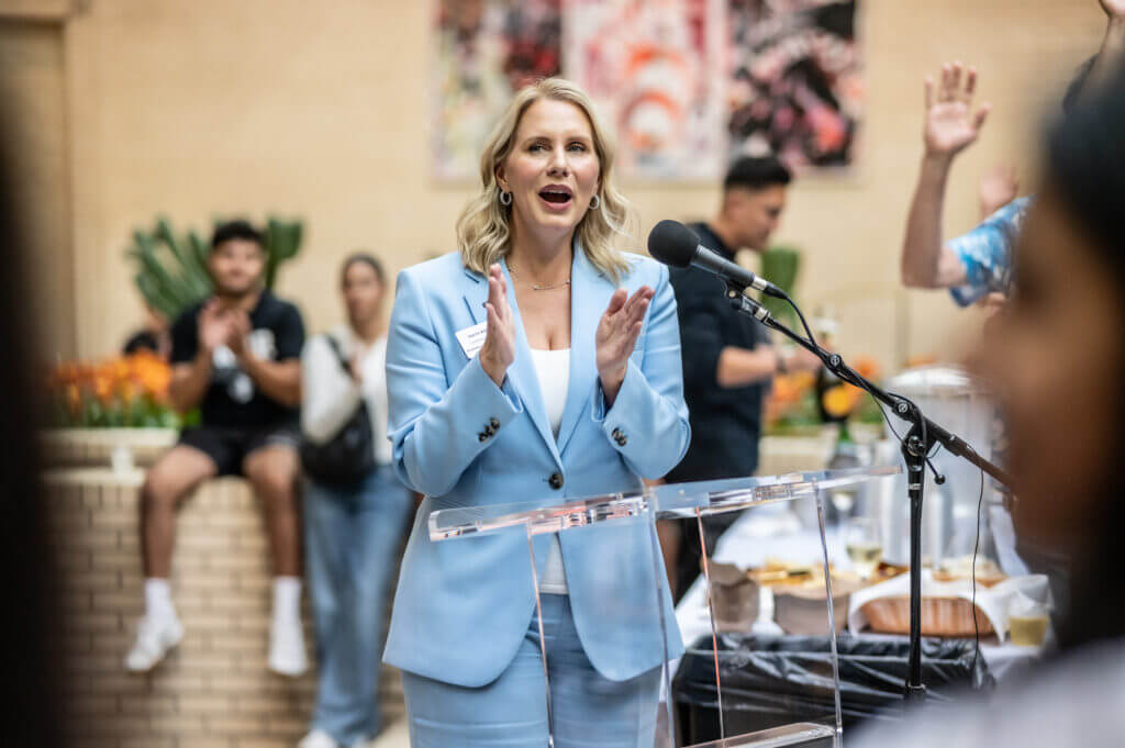 woman speaking into microphone clapping